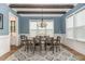 Stylish dining room features a wooden beam ceiling, chandelier, and abundant natural light at 251 Gentry Dr, Pittsboro, NC 27312