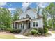 Charming two-story home with a light blue exterior, stone accents, and lush landscaping at 251 Gentry Dr, Pittsboro, NC 27312