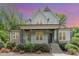Charming home with stone accents, a covered porch, and meticulous landscaping under a vibrant sunset sky at 251 Gentry Dr, Pittsboro, NC 27312