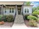Inviting stone steps leading to a covered porch and front door framed by lush landscaping at 251 Gentry Dr, Pittsboro, NC 27312