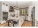 Modern kitchen features white cabinets, stainless steel appliances, and an island with bar seating at 251 Gentry Dr, Pittsboro, NC 27312