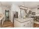 Open kitchen layout with stainless steel refrigerator and center island adjacent to the staircase at 251 Gentry Dr, Pittsboro, NC 27312