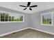 This bright bedroom has two large windows and a ceiling fan at 2710 E Greensboro Chapel Hill Rd, Snow Camp, NC 27349