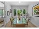 Bright dining room with glass table, six chairs, and scenic backyard views through large windows at 30 Futrell Ridge Ct, Chapel Hill, NC 27517