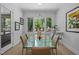 Bright dining room with large window, hardwood floors, glass table, and modern lighting fixture at 30 Futrell Ridge Ct, Chapel Hill, NC 27517