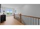 Bright hallway features wood floors, black metal railing, and a window offering beautiful views at 30 Futrell Ridge Ct, Chapel Hill, NC 27517