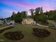 Exterior shot of a home at dusk, showcasing the well-lit yard and meticulously kept lawn at 30 Futrell Ridge Ct, Chapel Hill, NC 27517
