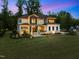 Exterior shot of a home at dusk, showcasing the well-lit yard and meticulously kept lawn at 30 Futrell Ridge Ct, Chapel Hill, NC 27517