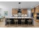 Kitchen island with seating, modern lighting, wood cabinets, and stainless steel appliances at 30 Futrell Ridge Ct, Chapel Hill, NC 27517