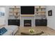 Living room view with a modern fireplace, built-in shelving, sleek cabinets, and a comfortable gray sectional sofa at 30 Futrell Ridge Ct, Chapel Hill, NC 27517