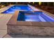 Inviting backyard pool and spa with beautiful stone accents and illuminated blue water at twilight at 30 Futrell Ridge Ct, Chapel Hill, NC 27517
