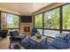 Comfortable sunroom with a fireplace, TV, and views of the pool and backyard at 30 Futrell Ridge Ct, Chapel Hill, NC 27517