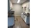 Galley kitchen with granite countertops and white cabinets and neutral colored flooring at 3049 Huntleigh Dr, Raleigh, NC 27604