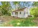 Quaint home showcasing lush green grass, mature trees, and a fenced-in yard at 331 Highland Ave, Burlington, NC 27217