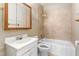 Bathroom featuring a combination tub and shower, vanity, and neutral-toned tiled walls at 331 Highland Ave, Burlington, NC 27217