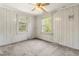 Sunlit bedroom with white paneled walls, two windows, and a ceiling fan fixture at 331 Highland Ave, Burlington, NC 27217
