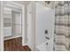 Bright bathroom featuring a shower over tub with white tile and a linen shower curtain at 3608 Deering Dr, Raleigh, NC 27616