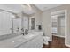 Modern bathroom featuring a vanity with white marble countertop, walk-in closet, and tiled shower at 3608 Deering Dr, Raleigh, NC 27616