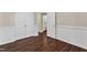 This bedroom features wood-look floors, wainscoting, and an ensuite bathroom at 3608 Deering Dr, Raleigh, NC 27616