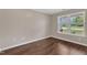 This bedroom features a window offering lots of natural light and beautiful wood-look floors at 3608 Deering Dr, Raleigh, NC 27616