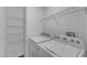 Well-lit laundry room with Whirlpool washer and dryer and wire shelving at 3608 Deering Dr, Raleigh, NC 27616