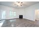 Spacious living room with a fireplace, ceiling fan, large window, and a glass door leading to a porch at 37 Shoreline Dr, Lillington, NC 27546