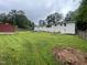 Spacious backyard with mature trees, well-kept grass, blue chairs and a red shed at 3725 Fernwood Dr, Raleigh, NC 27612