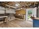 Unfinished basement area with exposed ceiling, workbench, and walkout access at 3725 Fernwood Dr, Raleigh, NC 27612