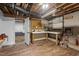 Basement workshop with ample workspace, storage shelves, and visible ceiling beams at 3725 Fernwood Dr, Raleigh, NC 27612