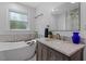 Luxurious bathroom featuring a standalone tub and elegant vanity with marble countertop and modern fixtures at 3725 Fernwood Dr, Raleigh, NC 27612