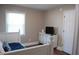 Bright bedroom featuring neutral walls, wood flooring, and a TV on a stylish white cabinet at 3725 Fernwood Dr, Raleigh, NC 27612