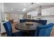 Spacious dining area adjacent to the kitchen features a dark table and four comfortable blue velvet chairs at 3725 Fernwood Dr, Raleigh, NC 27612