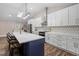 Bright kitchen featuring an island with seating, stylish backsplash, modern cabinets, and stainless appliances at 3725 Fernwood Dr, Raleigh, NC 27612