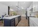 Open-concept kitchen flowing into the living area has an island with stainless steel appliances and quartz countertops at 3725 Fernwood Dr, Raleigh, NC 27612