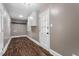 Well-lit laundry room with white cabinets, wood-look flooring, and a door with glass panels at 3725 Fernwood Dr, Raleigh, NC 27612