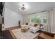 Stylish living room with a modern fireplace, cozy seating, a decorative rug, and natural light from large windows at 3725 Fernwood Dr, Raleigh, NC 27612