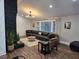 Comfortable living area with a dark leather sofa, a decorative fireplace, and natural light from large windows at 3725 Fernwood Dr, Raleigh, NC 27612