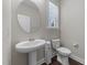 Cozy half bath with a pedestal sink, sleek fixtures, and natural light from the window at 4009 Reunion Creek Pkwy, Apex, NC 27539