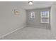Empty carpeted bedroom with two windows and neutral-colored walls, providing ample light at 4009 Reunion Creek Pkwy, Apex, NC 27539