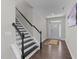 Bright entryway with hardwood floors, staircase with black banister, and decorative rug creating a warm ambiance at 4009 Reunion Creek Pkwy, Apex, NC 27539
