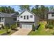 Two-story home featuring a garage, stone accents, neutral siding, pleasant landscaping and green shutter accents at 4009 Reunion Creek Pkwy, Apex, NC 27539