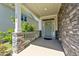 Inviting front porch with stone accents and a stylish entrance door, providing a welcoming curb appeal at 4009 Reunion Creek Pkwy, Apex, NC 27539