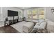 Inviting living room with large windows, hardwood floors, and a comfortable sectional sofa at 4009 Reunion Creek Pkwy, Apex, NC 27539