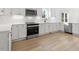 Bright kitchen featuring white cabinetry, stainless steel appliances, light wood floors, and modern countertops at 431 Longfellow St, Fuquay Varina, NC 27526