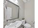 Stylish half bathroom features a pedestal sink with a large mirror, tiled floors, and neutral paint at 449 Sandy Whispers Pl, Cary, NC 27519