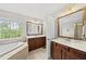 Bright bathroom boasts dual vanities, framed mirrors, soaking tub and natural light at 449 Sandy Whispers Pl, Cary, NC 27519