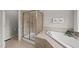 Bathroom featuring a walk-in shower, soaking tub and neutral tile at 449 Sandy Whispers Pl, Cary, NC 27519