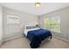 Bright bedroom with plush carpeting, two windows and a comfortable queen bed at 449 Sandy Whispers Pl, Cary, NC 27519