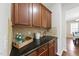 Butler's pantry featuring dark wood cabinets, granite countertop, and ample storage for entertaining essentials at 449 Sandy Whispers Pl, Cary, NC 27519