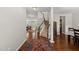 Inviting entryway with hardwood floors, staircase, and decorative rug leading to dining and living areas at 449 Sandy Whispers Pl, Cary, NC 27519